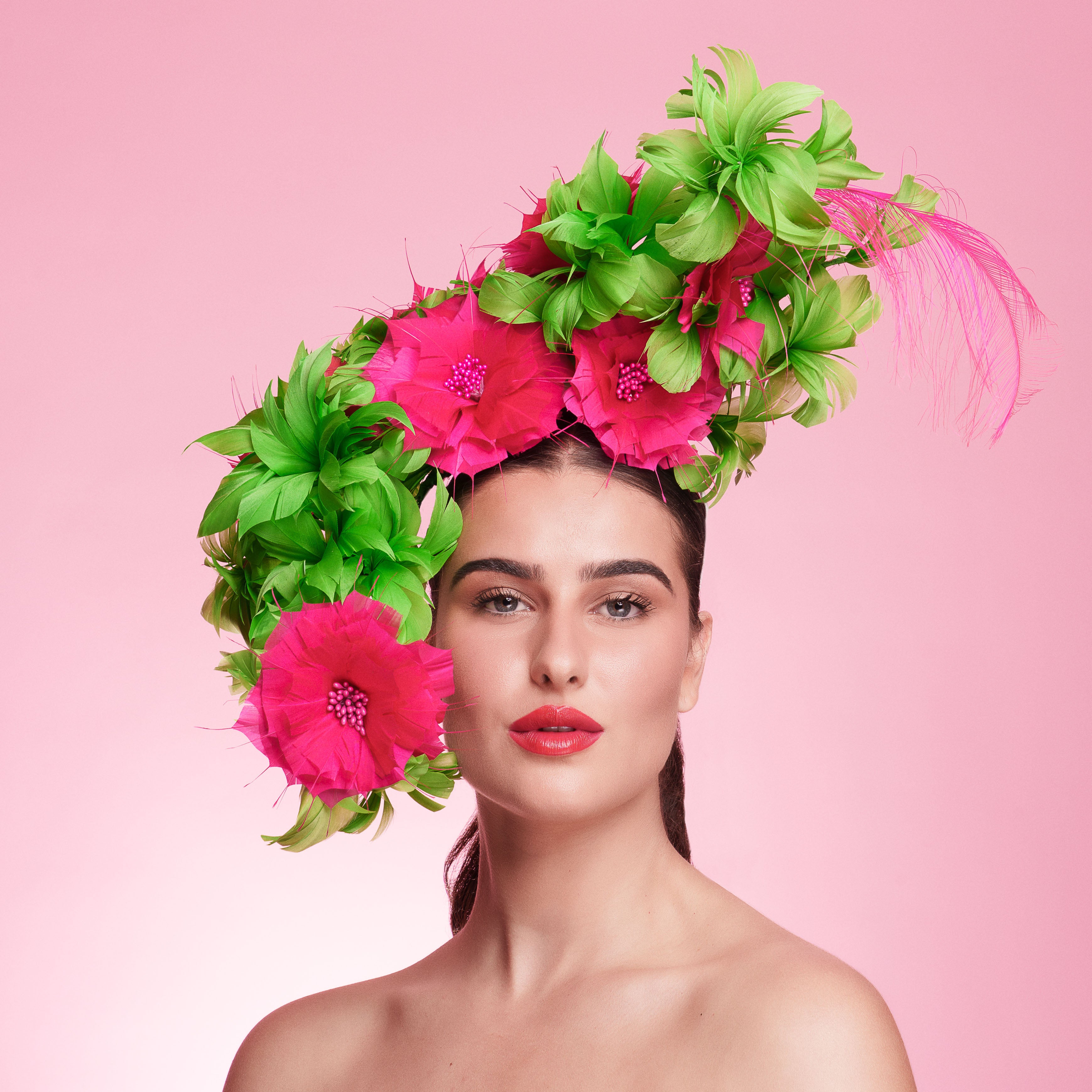Woman wearing a floral headpiece with pink and green flowers on a pink background