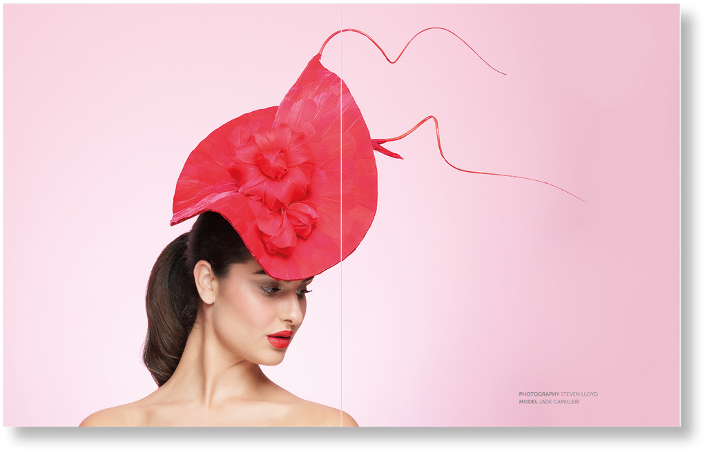 Woman wearing a large red hat against a pink background